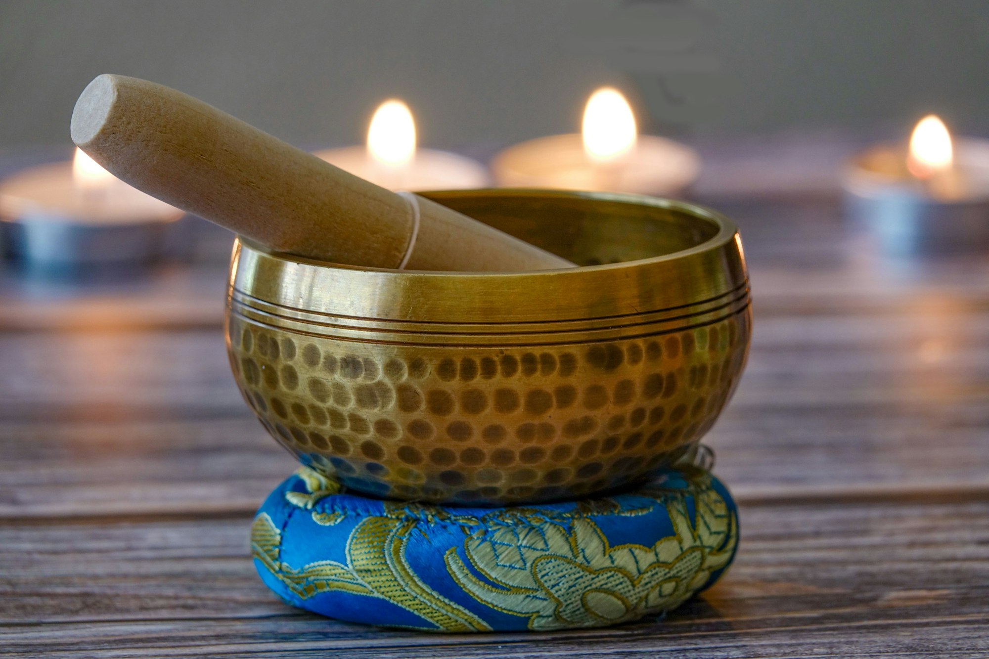 Hand-hammered Tibetan singing bowl set for meditation with candles in the background